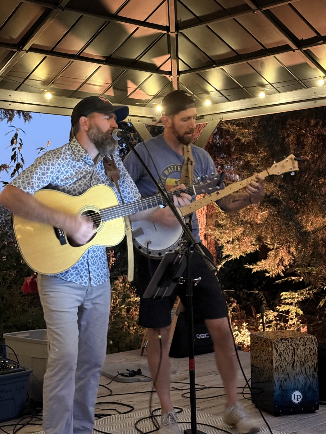Mike & Adam performing live acoustic music together under string lights